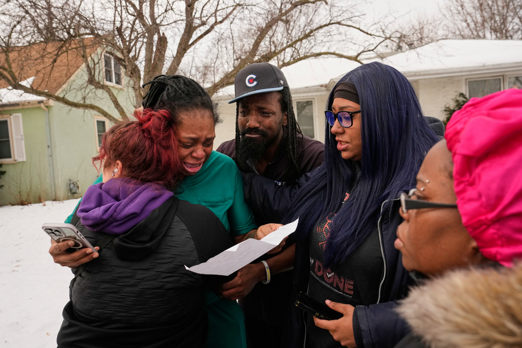 ADDS IDENTIFICATION: Teyana Gibson Brown, second from left, wife of Garrison Gibson, reacts after federal immigration officers arrested Garrison Gibson, Sunday, Jan. 11, 2026, in Minneapolis. (AP Photo/John Locher)