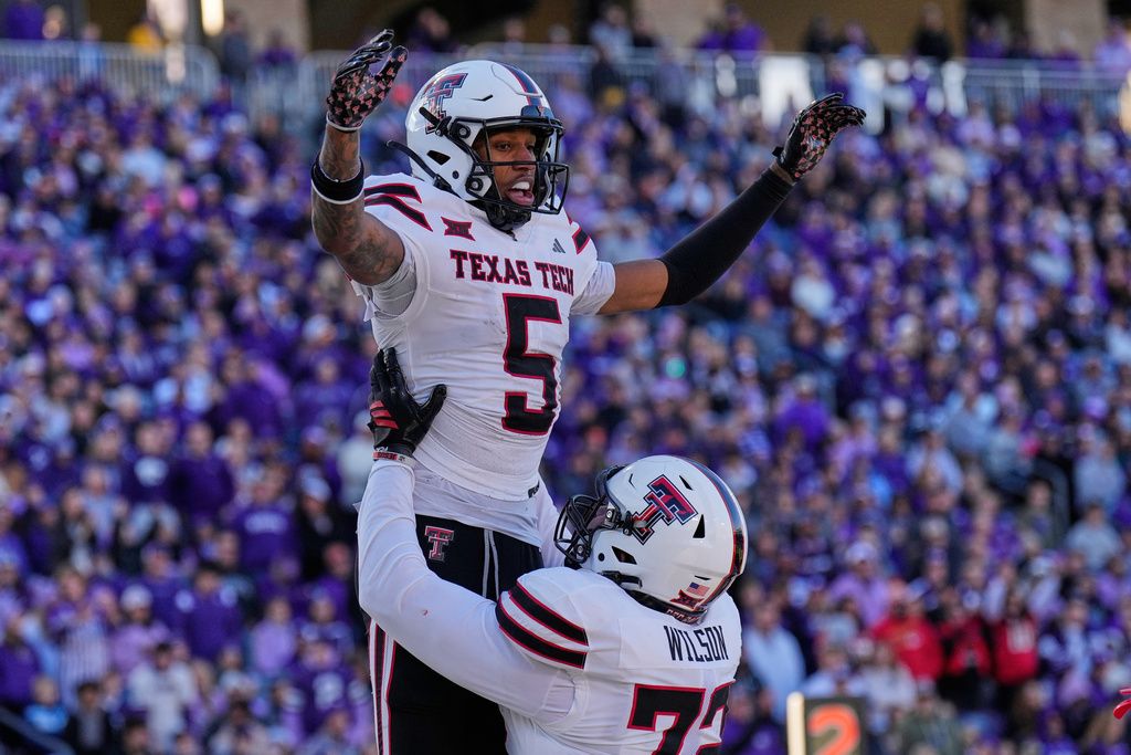Texas Tech wide receiver Caleb Douglas (5) celebrates with offensive lineman Sheridan Wilson after scoring a touchdown during the second half of an NCAA college football game against Kansas State, Saturday, Nov. 1, 2025, in Manhattan, Kan. (AP Photo/Charlie Riedel)