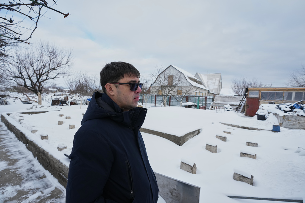Yaroslav Nehoda, 40, stands next to the site where his wife, daughter and niece were killed in a drone strike, in the Kyiv region of Ukraine, Thursday, Feb. 19, 2026. (AP Photo/Sergei Grits)