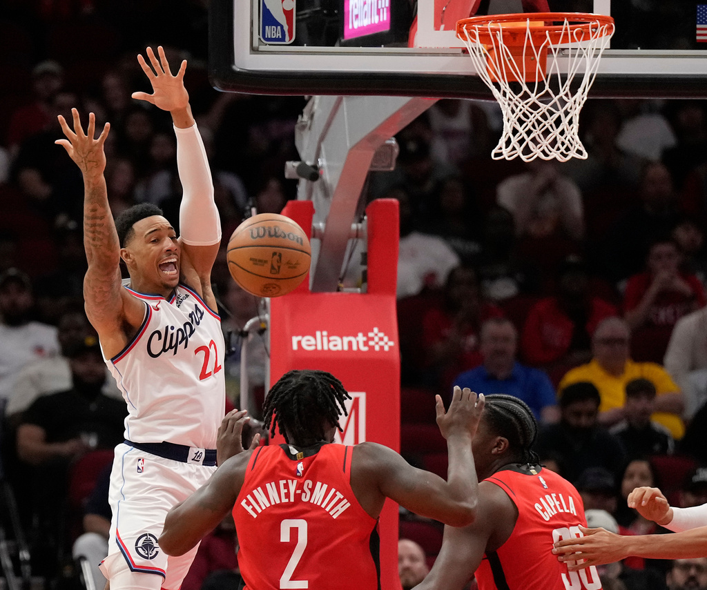 Los Angeles Clippers forward Jordan Miller (22) reacts as he loses control of the ball against Houston Rockets' Dorian Finney-Smith (2) and Clint Capela during the first half of an NBA basketball game, Tuesday, Feb. 10, 2026, in Houston. (AP Photo/ Karen Warren)