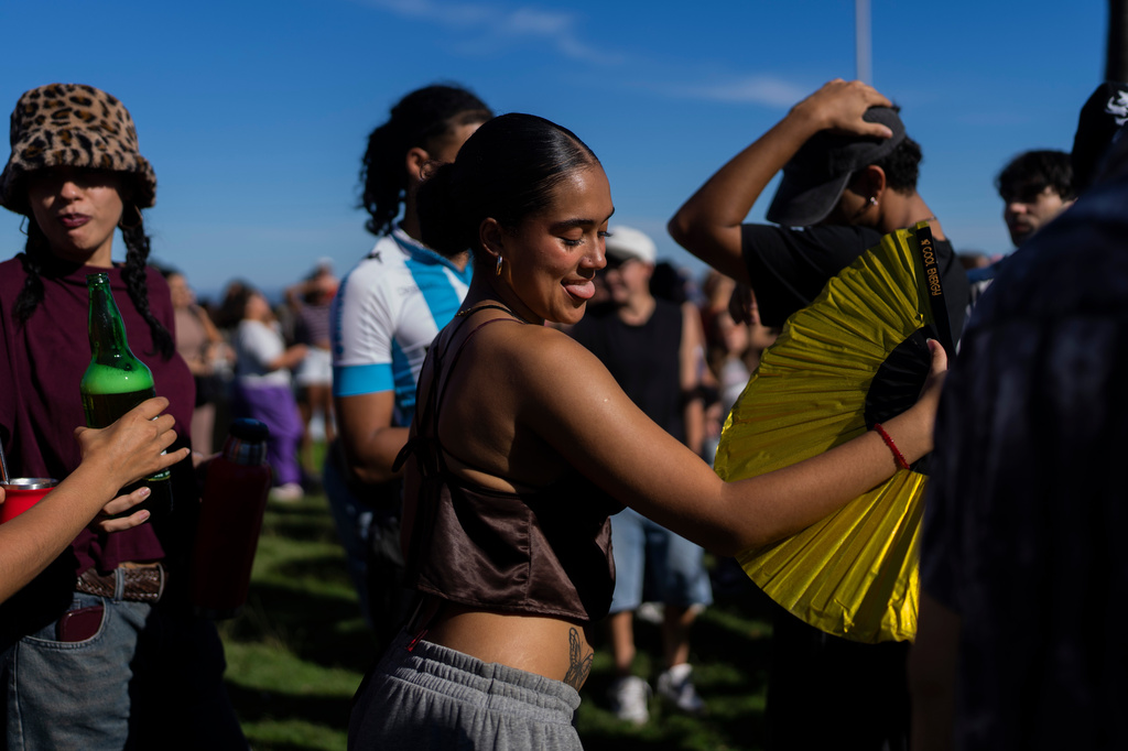 Spectators dance as musicians perform during the Rueda de Candombe at Plaza Espana in Montevideo, Uruguay, Sunday, April 19, 2026. (AP Photo/Matilde Campodonico)