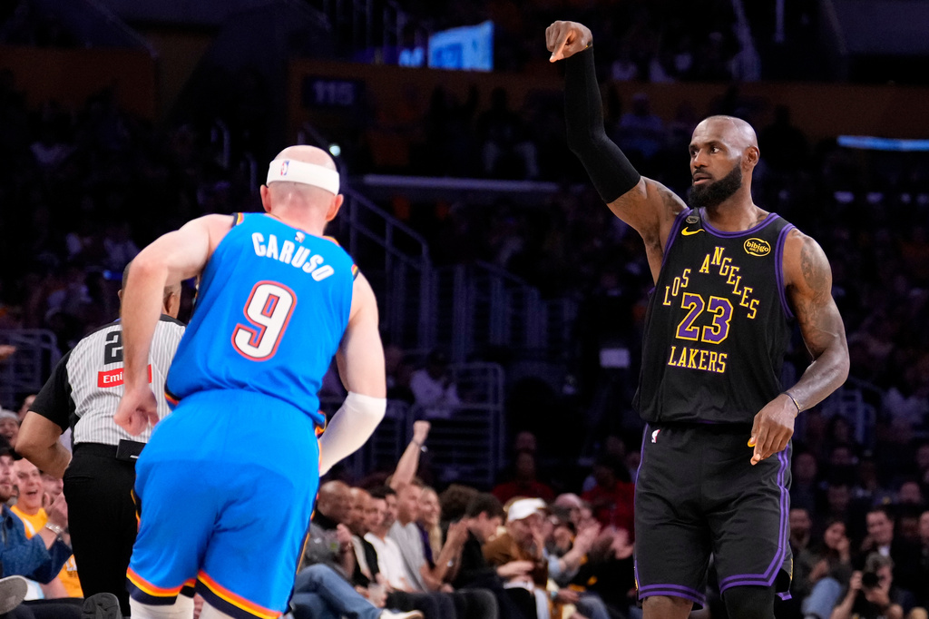 Los Angeles Lakers forward LeBron James, right, gestures after scoring as Oklahoma City Thunder guard Alex Caruso runs by during the first half of Game 4 in a second-round NBA basketball playoffs series Monday, May 11, 2026, in Los Angeles. (AP Photo/Mark J. Terrill)