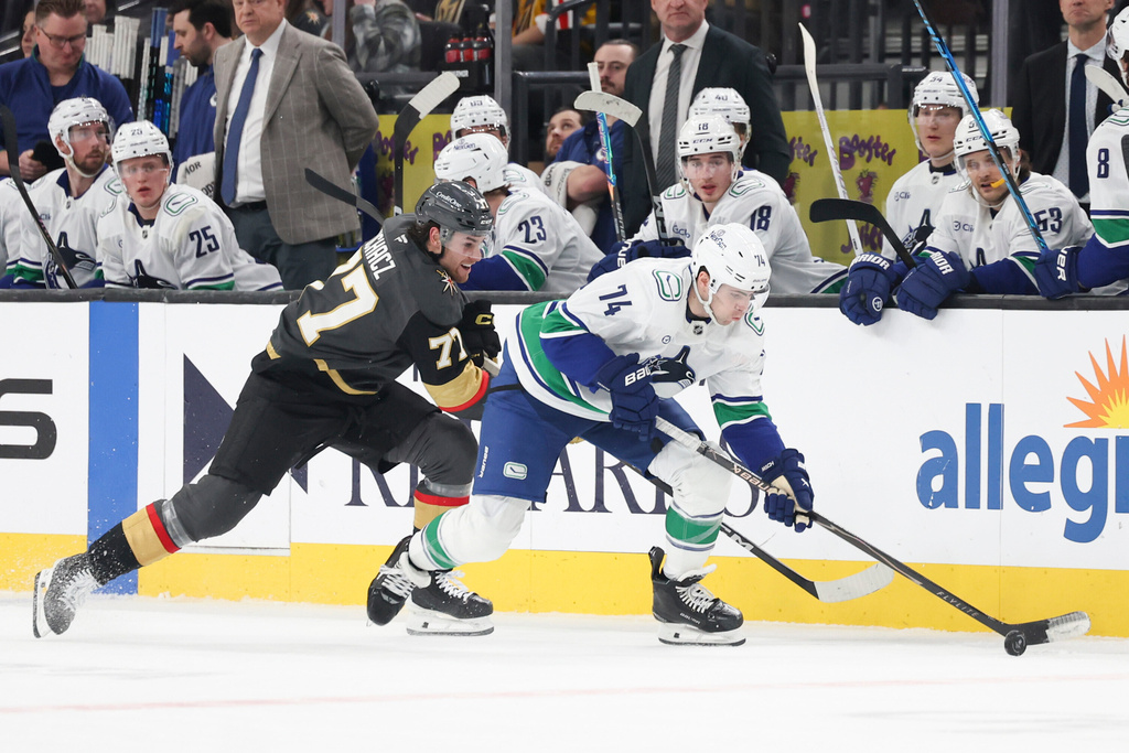 Vancouver Canucks left wing Jake DeBrusk (74) skates against Vegas Golden Knights center Kai Uchacz (77) during the first period of an NHL hockey game Wednesday, Feb. 4, 2026, in Las Vegas. (AP Photo/Ian Maule)