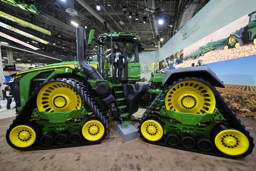 A convention goer exits a John Deere 9RX Tractor at the John Deere booth during the CES tech show Tuesday, Jan. 7, 2025, in Las Vegas. (AP Photo/John Locher)