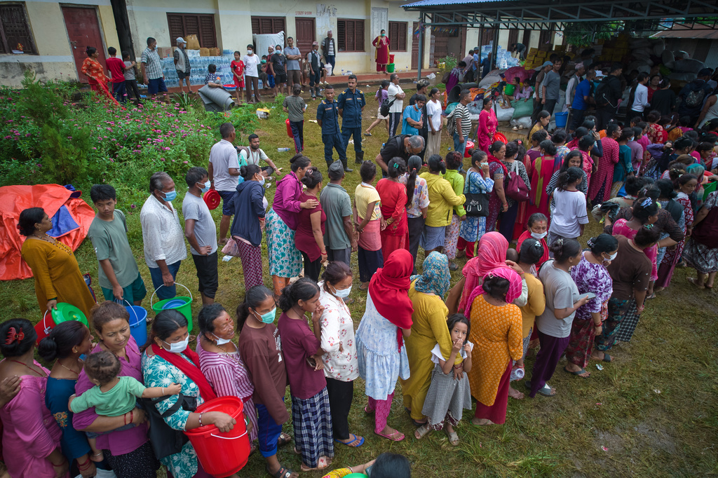 People affected by recent flash floods stand in line to receive aid at a school converted into a temporary shelter in Nepal’s Nuwakot district, Thursday, Sept. 3, 2026. (AP Photo/Rajesh Kumar Singh)