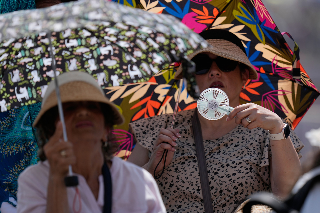 FILE - Faithful shelter from the hot sun as Pope Leo's XIV arrives for his weekly general audience in St. Peter's Square at The Vatican, June 24, 2026. (AP Photo/Alessandra Tarantino, File)