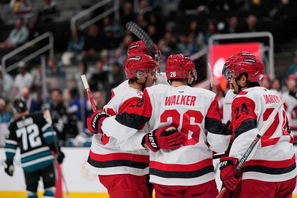 Carolina Hurricanes defenseman Sean Walker (26) celebrates with teammates after scoring a goal during the second period of an NHL hockey game against the San Jose Sharks, Tuesday, Oct. 14, 2025, in San Jose, Calif. (AP Photo/Godofredo A. Vásquez)