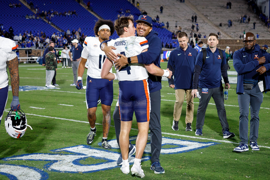 Virginia head coach Tony Elliott, right, hugs quarterback Chandler Morris (4) after beating Duke in an NCAA college football game in Durham, N.C., Saturday, Nov. 15, 2025. (AP Photo/Ben McKeown)