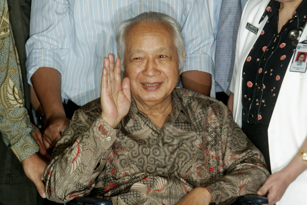 FILE - Former Indonesian President Suharto waves to journalists as he leaves a hospital after being treated for intestinal bleeding, in Jakarta, Indonesia, on May 5, 2004. (AP Photo/Dita Alangkara, File)