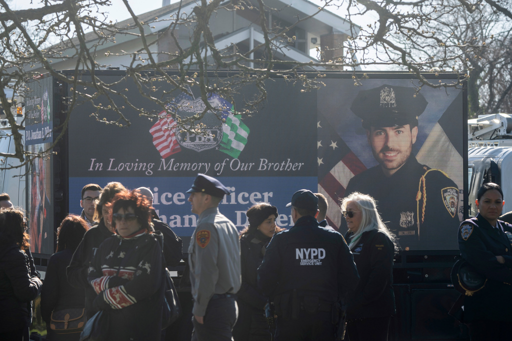 FILE - New York Police Department Officer Jonathan Diller is on a screen during his funeral service at Saint Rose of Lima R.C. Church in Massapequa Park, N.Y., March 30, 2024. (AP Photo/Jeenah Moon, File)