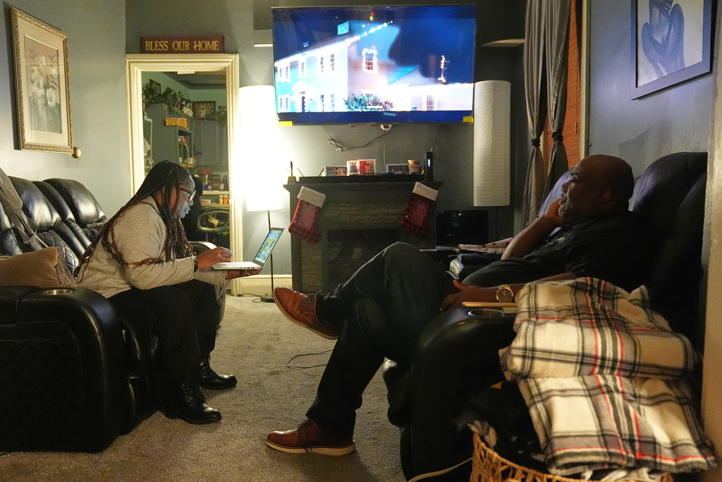 Ahmad Collins, watches television along with his wife Nickey Collins at their home in Harrisburg, Pa., Thursday, Dec. 11, 2025. A city government worker and former Penn State linebacker, Collins has needed 10 hours a night of dialysis since a medical procedure left him with damaged kidneys late last year. (AP Photo/Matt Rourke)