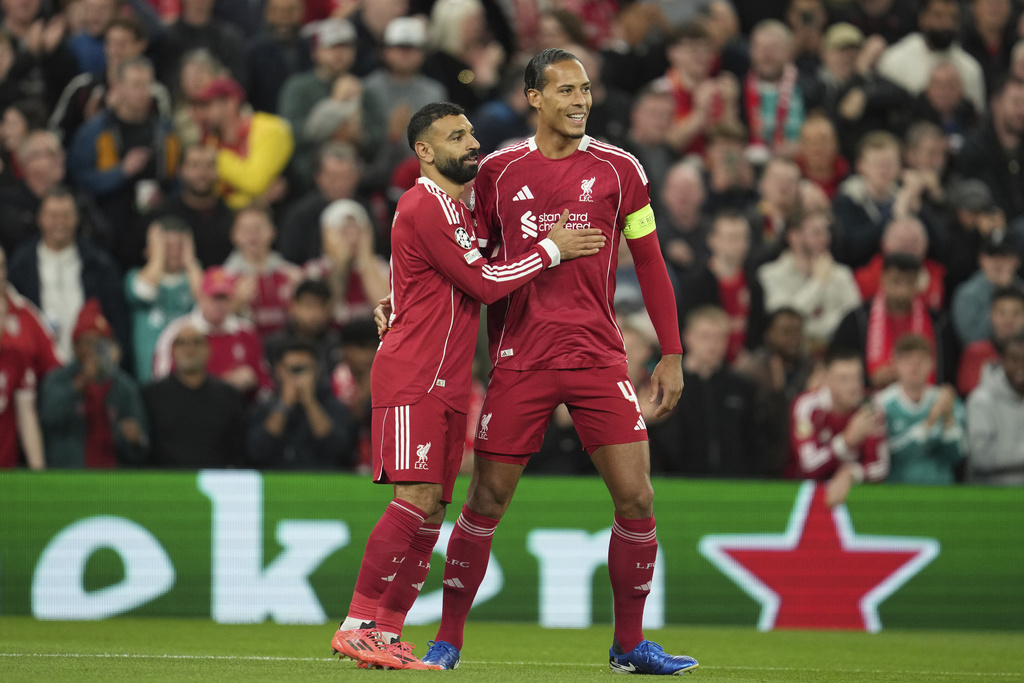 Liverpool's Mohamed Salah, left, celebrates with his teammate Virgil van Dijk after scoring his side's second goal during the Champions League opening phase soccer match between Liverpool and Atletico Madrid at Anfield stadium in Liverpool, England, Wednesday, Sept. 17, 2025. (AP Photo/Jon Super)