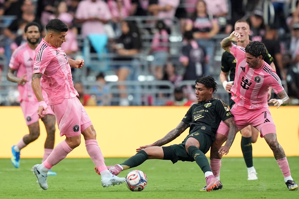 Portland Timbers forward Antony Alves Santos, center, comes under pressure from Inter Miami midfielder Rodrigo de Paul, right, and forward Luis Suarez, left, during the first half of an MLS soccer match, Sunday, May 17, 2026, in Miami. (AP Photo/Rebecca Blackwell)