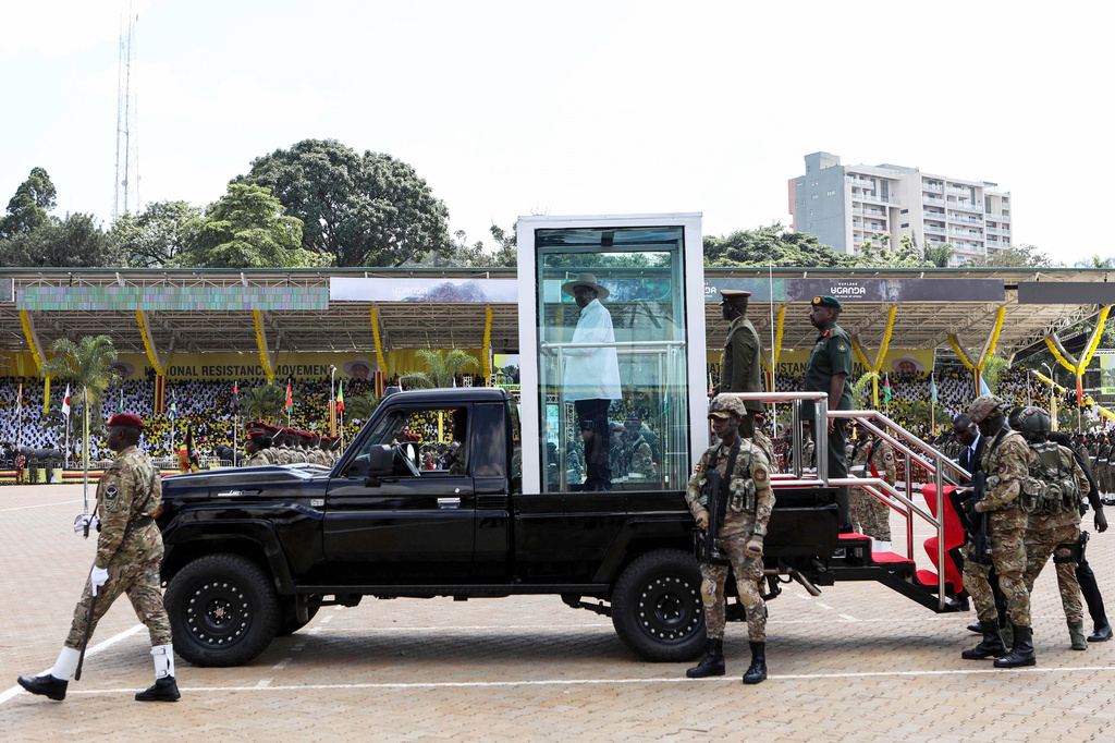 Uganda's long-time president Yoweri Museveni, 81, stands inside a glass booth as he reviews the honor guard during the inauguration ceremony for his seventh consecutive five-year term, in Kampala, Uganda, Tuesday, May 12, 2026. (AP Photo/Hajarah Nalwadda )