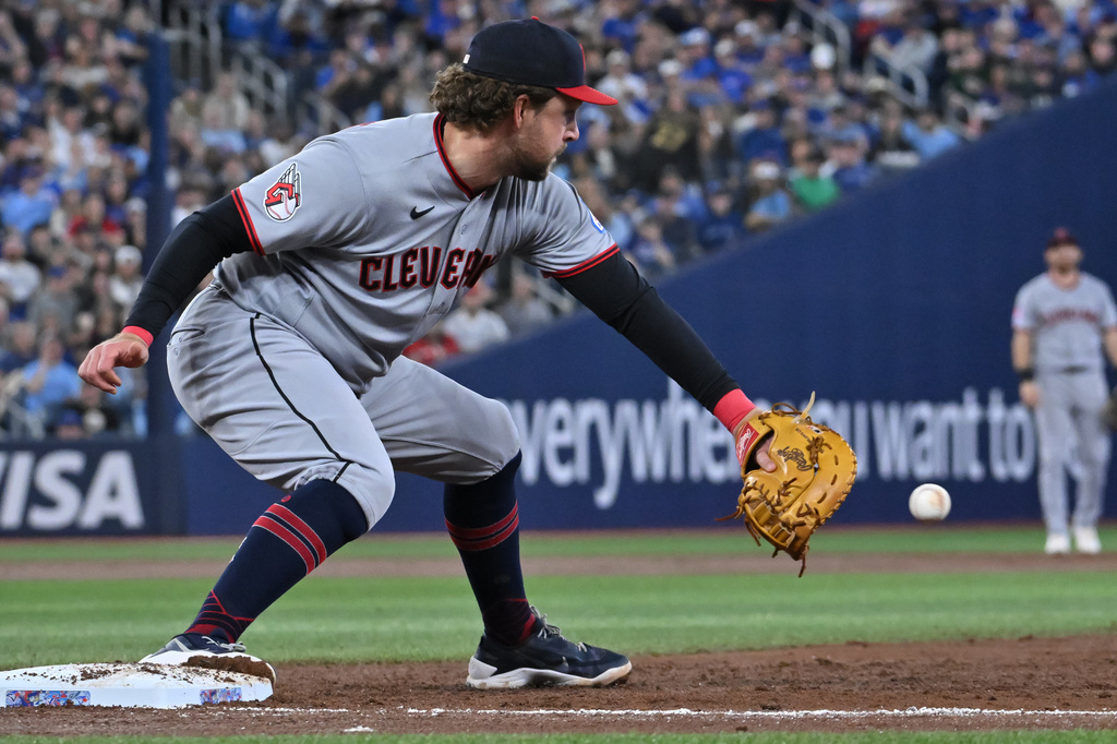Cleveland Guardians first baseman Rhys Hoskins takes a throw from shortstop Juan Brito to put out Toronto Blue Jays' Daulton Varsho in third-inning baseball game action in Toronto, Sunday, April 26, 2026. (Jon Blacker/The Canadian Press via AP)