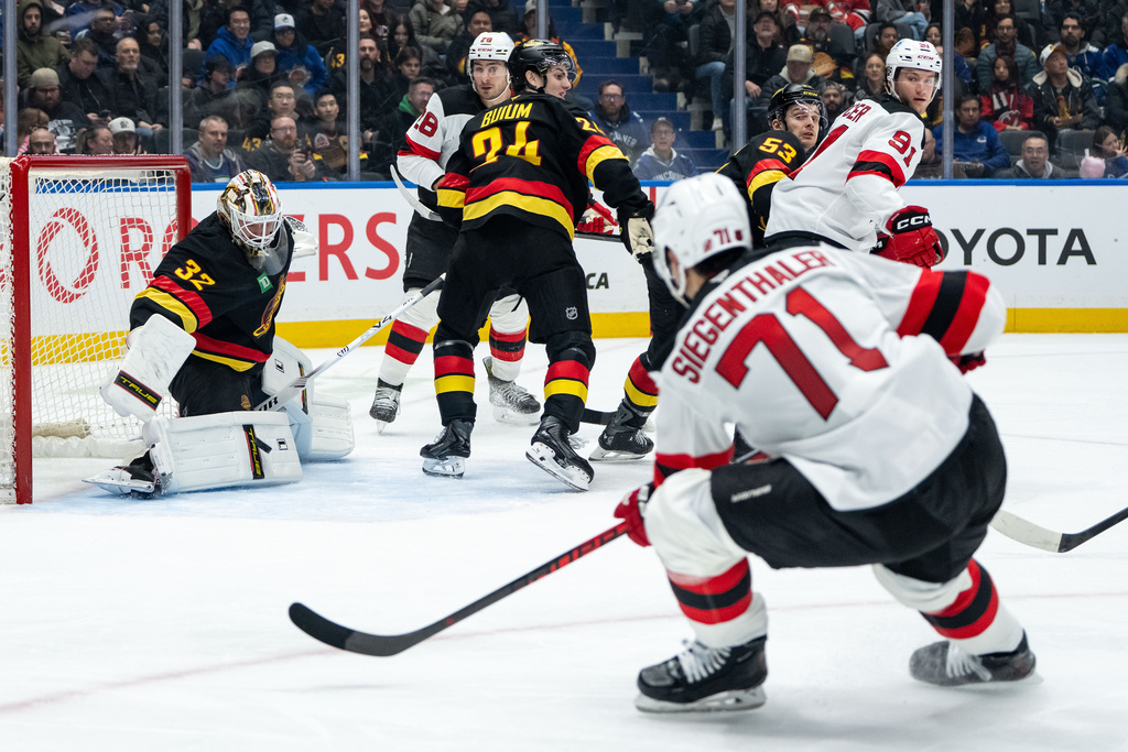 Vancouver Canucks goaltender Kevin Lankinen (32) stops New Jersey Devils' Jonas Siegenthaler (71) during the second period of an NHL hockey game in Vancouver, British Columbia, Friday, Jan. 23, 2026. (Ethan Cairns/The Canadian Press via AP)