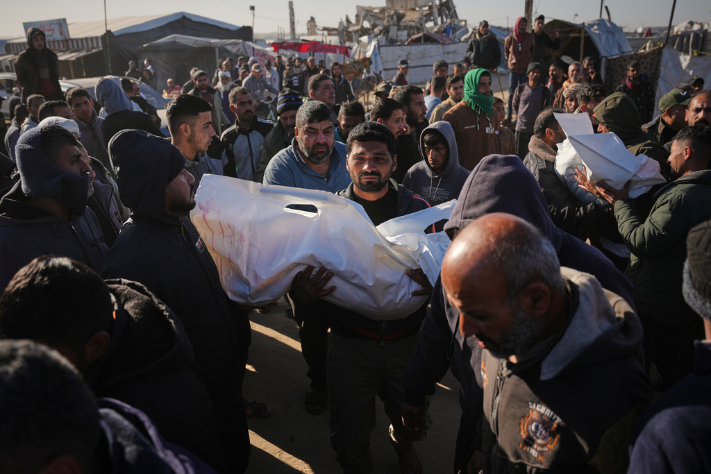 A Palestinian man carries the body of Sham Abu Hadaiyd, who was killed in an Israeli strike on a tent in Khan Younis, Gaza Strip, Saturday, Jan. 31, 2026. (AP Photo/Abdel Kareem Hana)