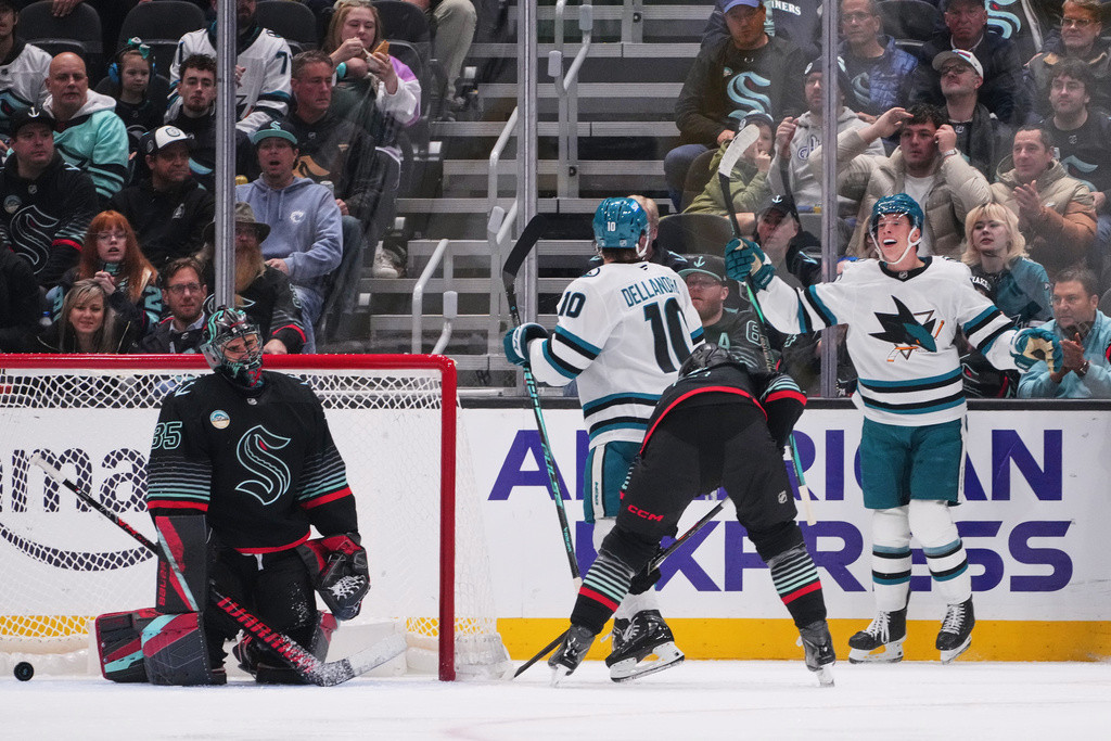 Seattle Kraken goaltender Joey Daccord (35) reacts to a goal by San Jose Sharks center Ty Dellandrea (10) as right wing Collin Graf, right, turns to celebrate during the third period of an NHL hockey game Wednesday, Nov. 5, 2025, in Seattle. (AP Photo/Lindsey Wasson)