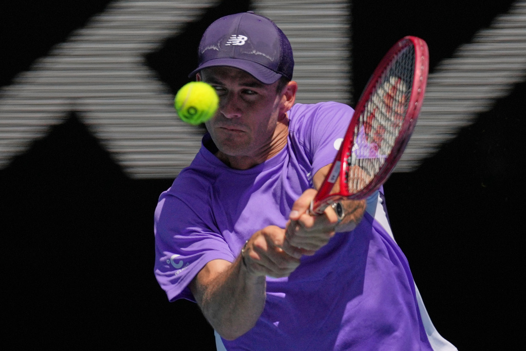 Tommy Paul of the U.S. plays a backhand return to Carlos Alcaraz of Spain during their fourth round match at the Australian Open tennis championship in Melbourne, Australia, Sunday, Jan. 25, 2026. (AP Photo/Dita Alangkara)