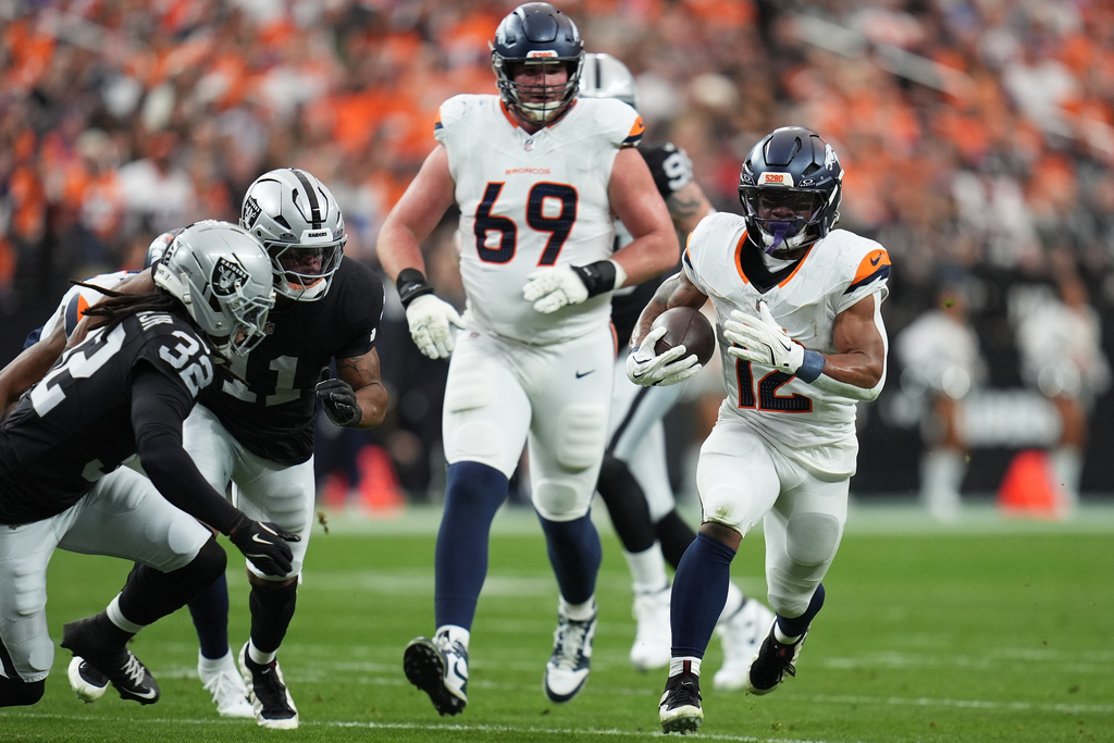 Denver Broncos running back RJ Harvey, right, runs against the Las Vegas Raiders during the first half of an NFL football game in Las Vegas, Sunday, Dec. 7, 2025. (AP Photo/Gregory Bull)