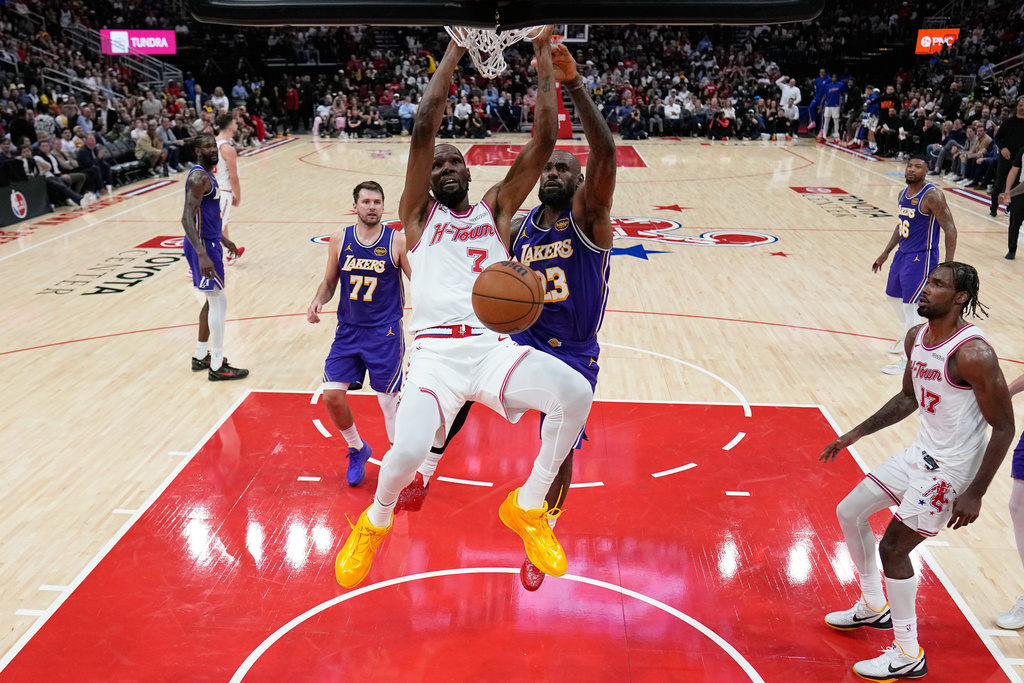 Houston Rockets' Kevin Durant (7) dunks the ball as Los Angeles Lakers' LeBron James (23) defends during the second half of an NBA basketball game Wednesday, March 18, 2026, in Houston. (AP Photo/David J. Phillip)
