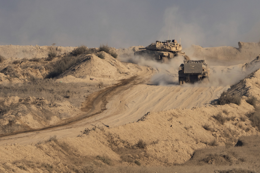 An Israeli tank and an armored personnel carrier (APC) move through an area of the Gaza Strip, as seen from southern Israel, Sunday, Aug. 31, 2025. (AP Photo/Maya Levin)