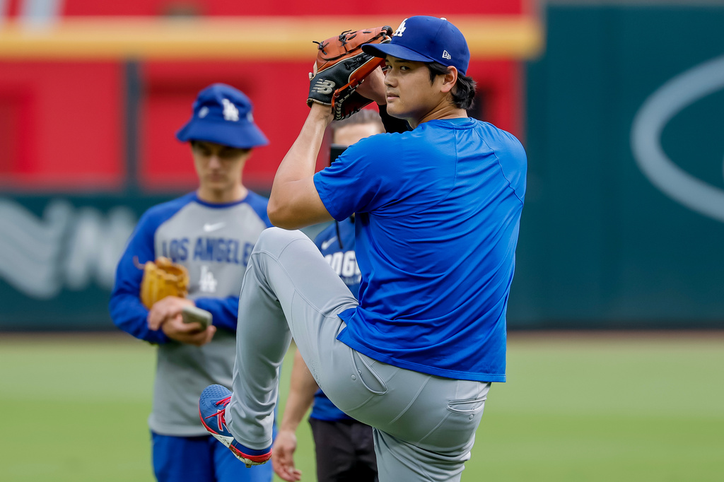 Los Angeles Dodgers pitcher Shohei Ohtani, front, winds up to throw during a practice session in the outfield before a baseball game against the Atlanta Braves, Thursday, Aug. 27, 2026, in Atlanta. (AP Photo/Erik S. Lesser)