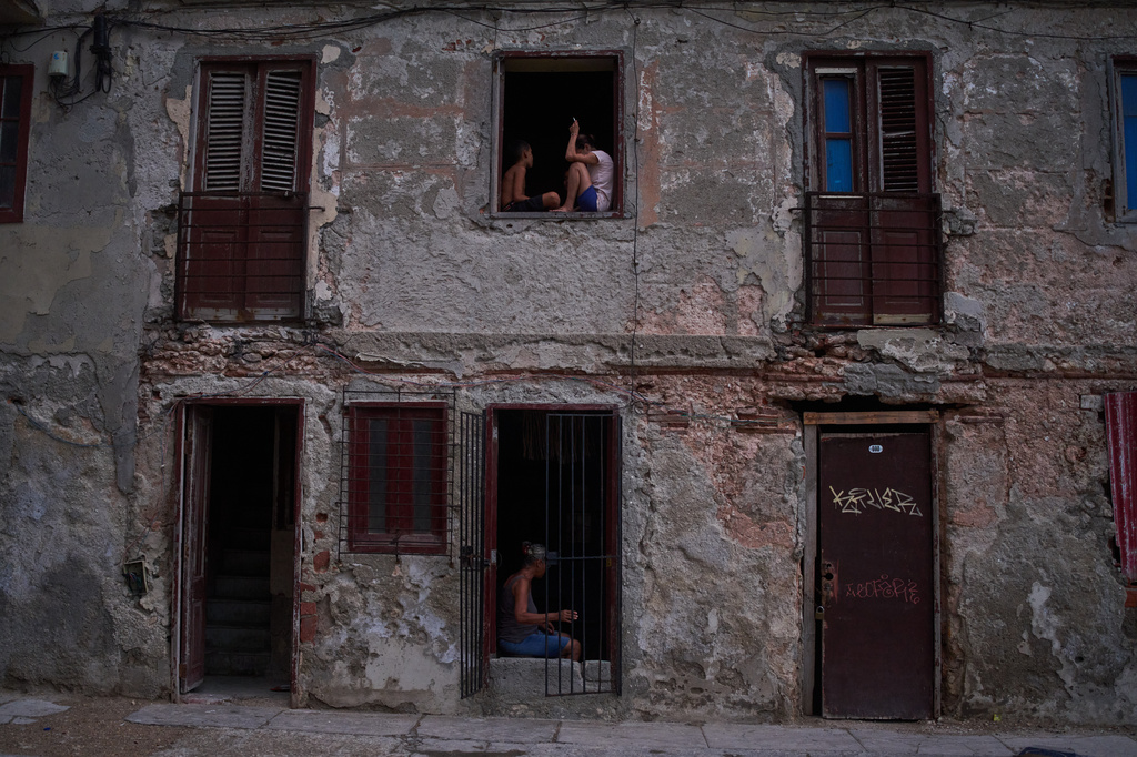 People catch the cool air from the street at their home's window during a blackout in Havana, Cuba, Friday, July 10, 2026. (AP Photo/Ramon Espinosa)