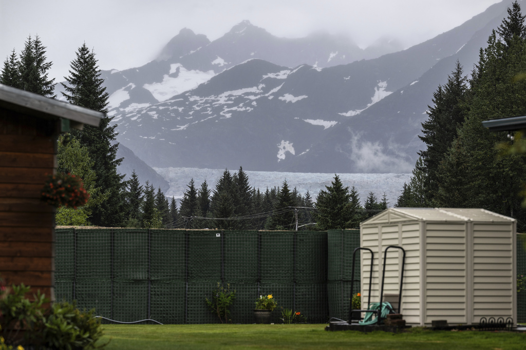 The Mendenhall Glacier is visible in the distance from a residential area, Sunday, Aug. 3, 2025, in Juneau, Alaska. (Marc Lester/Anchorage Daily News via AP)