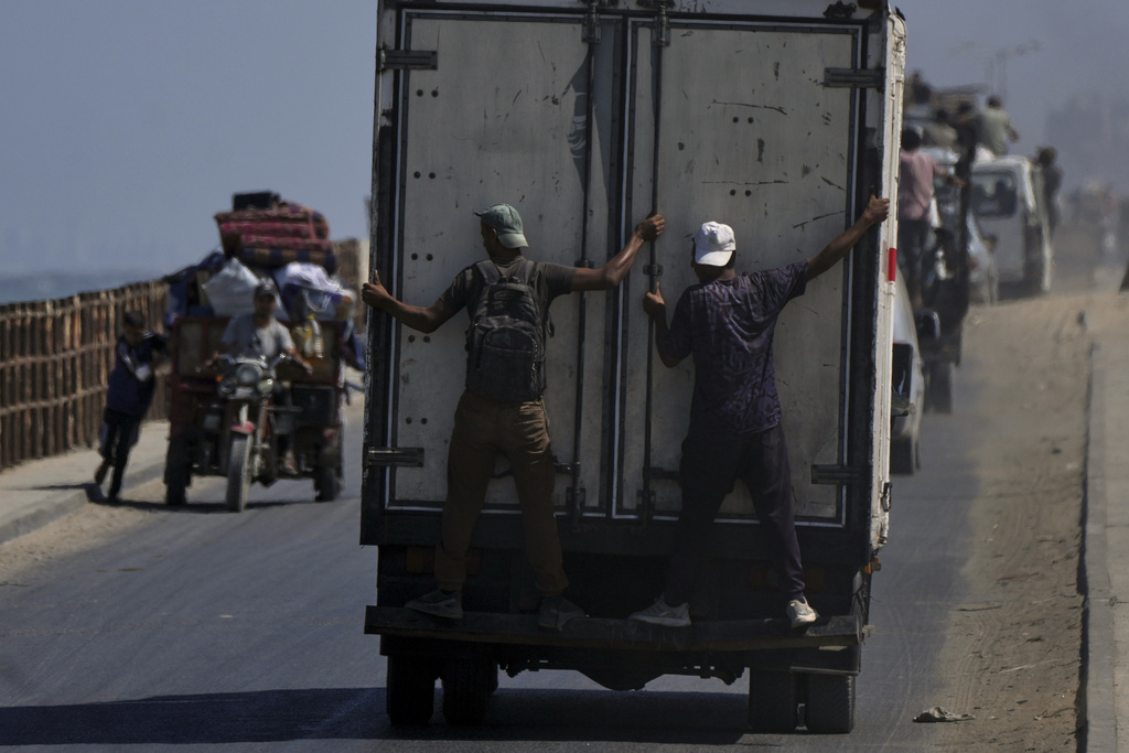 Displaced Palestinians fleeing northern Gaza carry their belongings along the coastal road toward southern Gaza, Tuesday, Sept. 9, 2025, after the Israeli army issued evacuation orders from Gaza City. (AP Photo/Jehad Alshrafi)