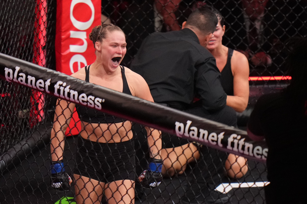Ronda Rousey, of the United States, left, celebrates after defeating Gina Carano, of the United States, right, in their featherweight mixed martial arts fight Saturday, May 16, 2026, in Inglewood, Calif. (AP Photo/Jae C. Hong )