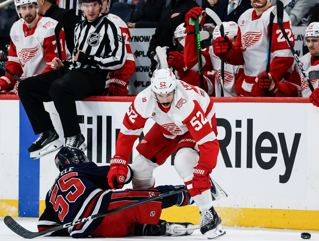 Detroit Red Wings' Travis Hamonic (52) collides with Winnipeg Jets' Mark Scheifele (55) during second-period NHL hockey game action in Winnipeg, Manitoba, Saturday, Jan. 24, 2026. (John Woods/The Canadian Press via AP)