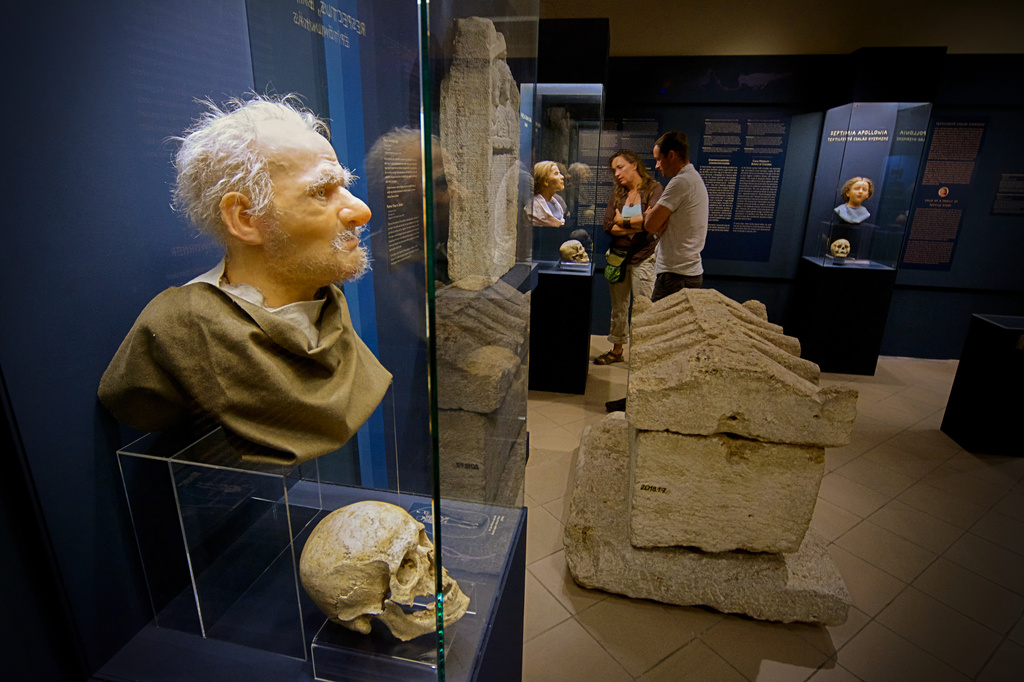 Visitors look at Roman-era skulls and their facial reconstructions in the Aquincum Museum's exhibition titled "Once we were like you" which showcases characters and the fictional life stories of those who once lived in the bustling Roman settlement of Aquincum, in Budapest, Hungary, Tuesday, July 7, 2026. (AP Photo/Bela Szandelszky)