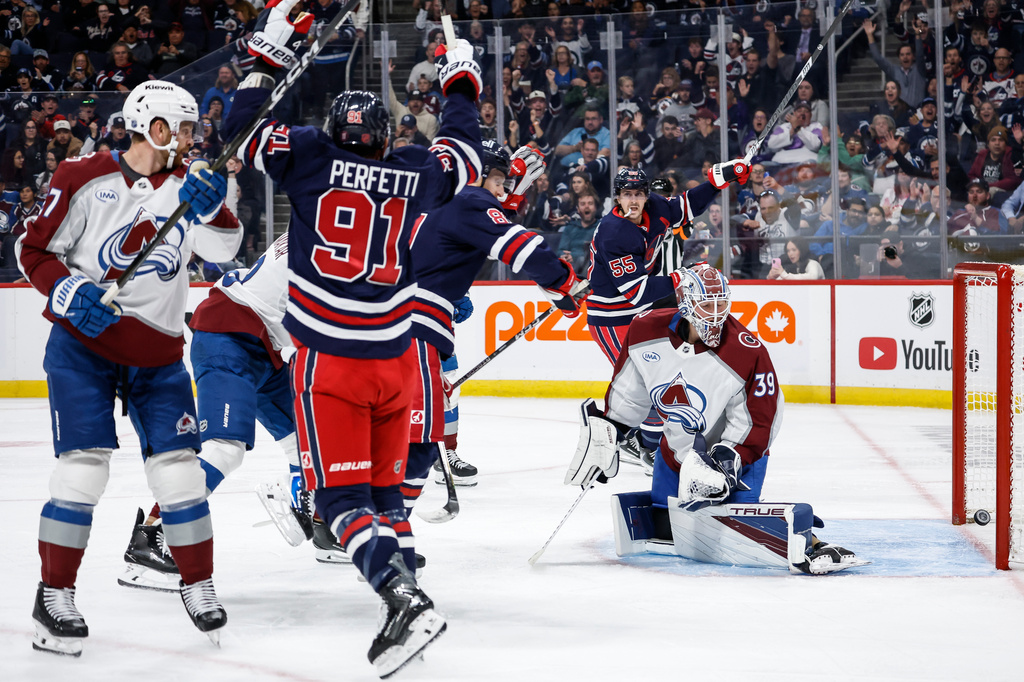 Winnipeg Jets' Cole Perfetti (91) and Mark Scheifele (55) celebrate Kyle Connor's (81) goal on Colorado Avalanche goaltender Mackenzie Blackwood (39) during the second period of an NHL hockey game in Winnipeg, Wednesday, Oct. 7, 2026. (John Woods/The Canadian Press via AP)