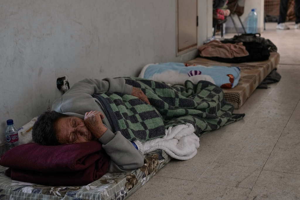 A displaced woman who fled Israeli airstrikes in southern Lebanon sleeps on the ground at the Bir Hassan Technical Institute, which has been turned into a shelter, in Beirut, Lebanon, Wednesday, March 11, 2026. (AP Photo/Bilal Hussein)