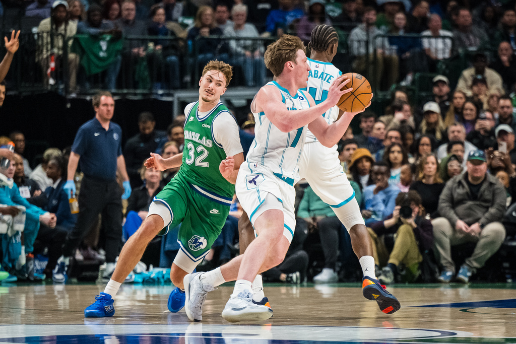 Charlotte Hornets guard Kon Knueppel (7) moves the ball away from Dallas Mavericks forward Cooper Flagg (32) during an NBA basketball game, Thursday, Jan. 29, 2026, in Dallas. (AP Photo/Jessica Tobias)