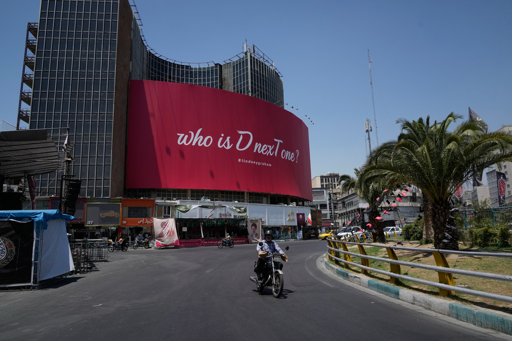 Vehicles drive by a billboard reading in English, "Who is D nexT one?" and "#lindseygraham," referring to late U.S. Sen. Lindsey Graham and using the capital letters "D" and "T" in an apparent play on the initials of U.S. President Donald Trump, in downtown Tehran, Iran, Thursday, July 16, 2026. (AP Photo/Vahid Salemi)