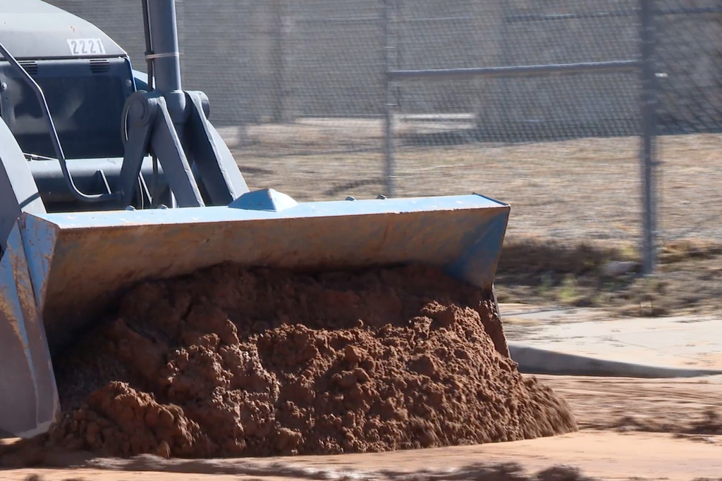 A still frame from video showed crews cleaning up mud left in the middle of the road after a water main break on Sunday, Jan. 11, 2026, in El Paso, Texas. (KFOX News via AP)