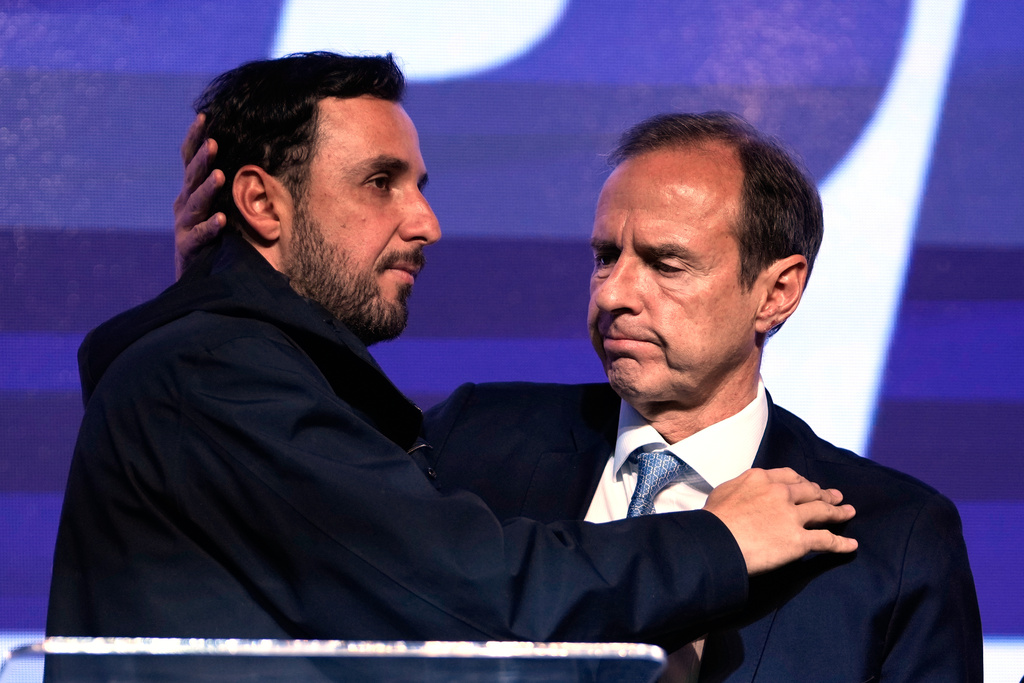 Presidential candidate Jorge "Tuto" Quiroga embraces running mate Juan Pablo Velasco, right, after early results showed them trailing in the presidential runoff election in La Paz, Bolivia, Sunday, Oct. 19, 2025. (AP Photo/Juan Karita)