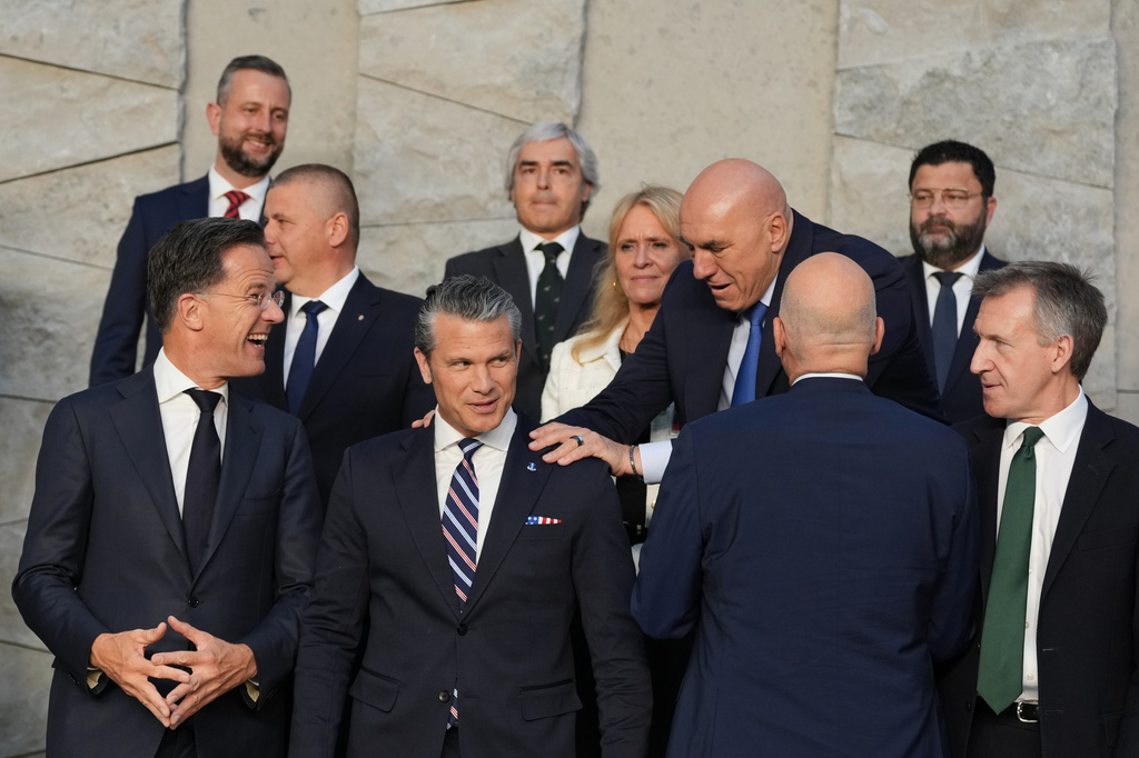 Italy's Defense Minister Guido Crosetto, fourth right, greets United States Defense Secretary Pete Hegseth, front second left, during a group photo of NATO defense ministers at NATO headquarters in Brussels, Thursday, June 18, 2026. (AP Photo/Virginia Mayo)
