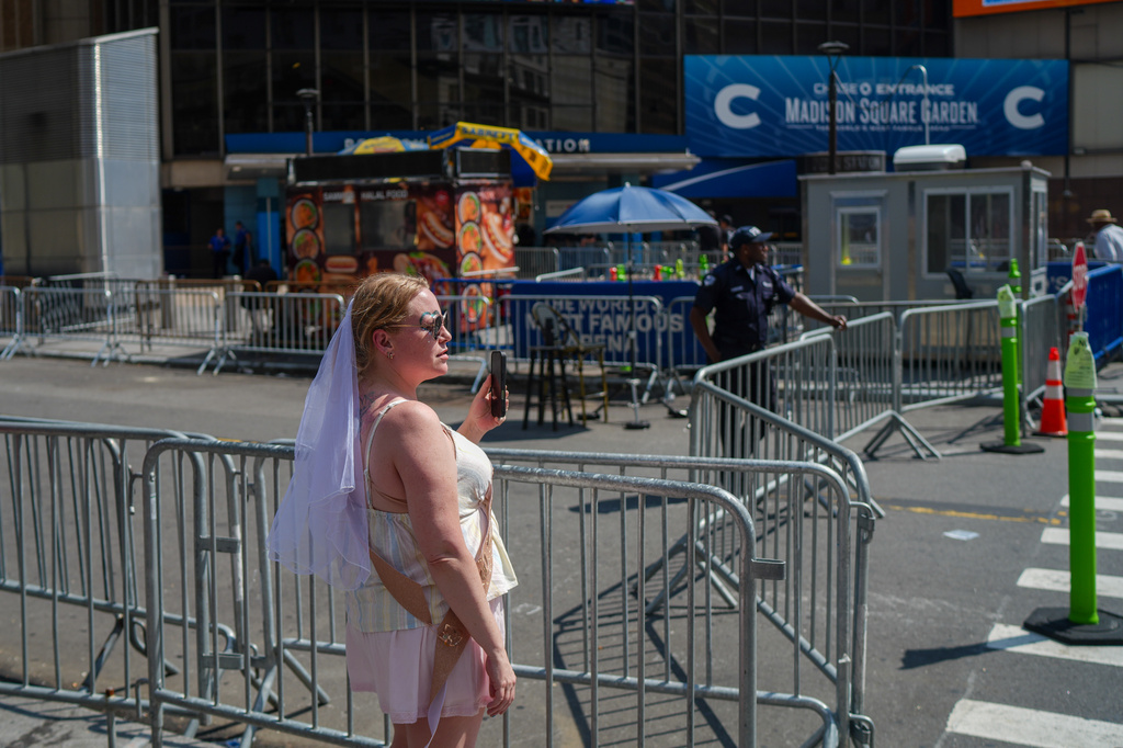 A woman wearing a bridal veil stands outside of Madison Square Garden ahead of a reported wedding between singer Taylor Swift and National Football League player Travis Kelce on Friday, July 3, 2026, in New York. (AP Photo/Ryan Murphy)