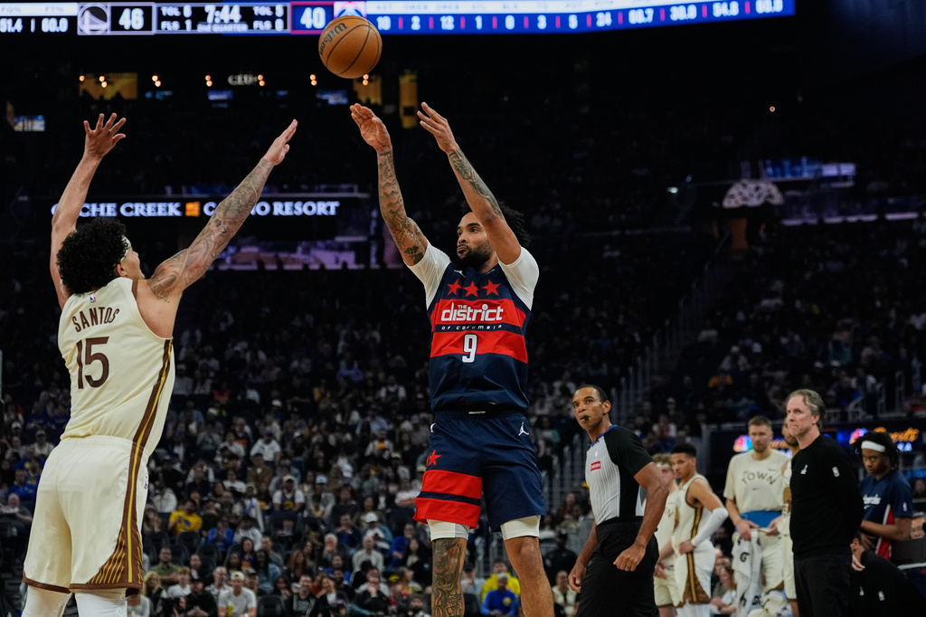 Washington Wizards forward Justin Champagnie (9) shoots a 3-point basket over Golden State Warriors forward Gui Santos (15) during the first half of an NBA basketball game, Friday, March 27, 2026, in San Francisco. (AP Photo/Godofredo A. Vásquez)
