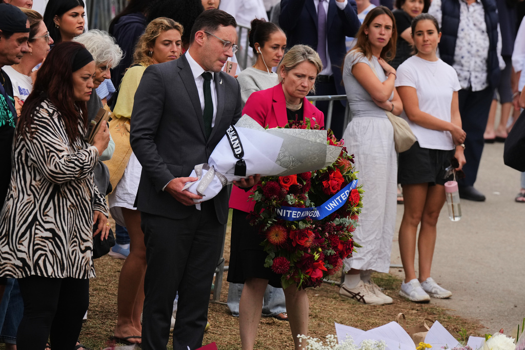 British Consul General Louise Cantillon, arrives at a memorial with flowers and a wreath during a tribute for victims of Sunday's shooting at the Bondi Pavilion at Bondi Beach on Tuesday, Dec. 16, 2025, in Sydney, Australia. (AP Photo/Mark Baker)