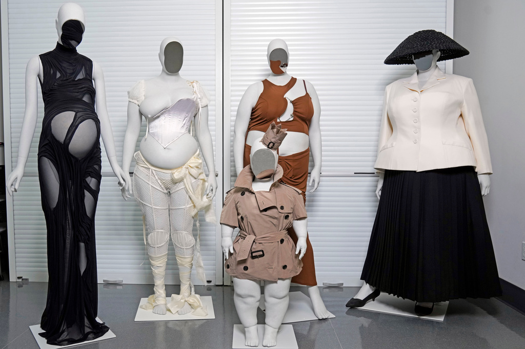 A Di Petsa dress by designer Dimitra Petsa appears on a pregnant mannequin, from left, an ensemble by Michaela Stark on a mannequin in Stark's image, a Burberry ensemble by Christopher Bailey on a mannequin image of Sinéad Burke, foreground, an ensemble by designer Karoline Vitto, on a mannequin model of Charlie Reynolds, and an outfit by designer Maria Grazia Chiuri for the House of Dior on a mannequin model of Yseult, are displayed in a room at the Metropolitan Museum of Art during preparations for the Met Gala exhibit "Costume Art" on Tuesday, April 14, 2026, in New York. (Photo by Charles Sykes/Invision/AP)