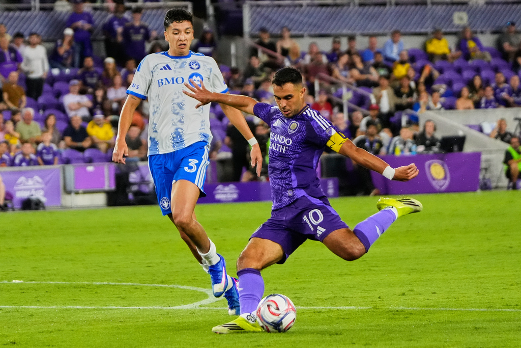 Orlando City midfielder Martin Ojeda (10) takes a shot on goal ahead of CF Montreal defender Tomas Aviles (3) during the second half of an MLS soccer match, Saturday, March 14, 2026, in Orlando, Fla. (AP Photo/John Raoux)