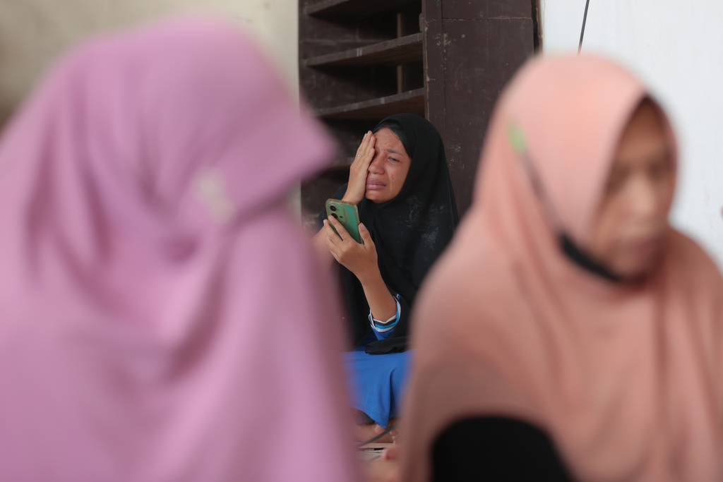 A woman weeps as rescue works are underway for victims trapped under the rubble after a building under construction collapsed at an Islamic boarding school in Sidoarjo, East Java, Indonesia, Wednesday, Oct. 1, 2025. (AP Photo/Trisnadi)