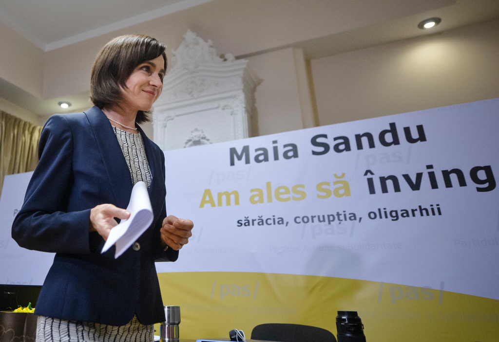 FILE - Pro-European presidential candidate Maia Sandu walks by a banner thet reads "I chose to defeat poverty, corruption, oligarchs" after voting ended in the presidential elections, in Chisinau, Moldova, Sunday, Nov. 13, 2016. (AP Photo/Andreea Alexandru, File)