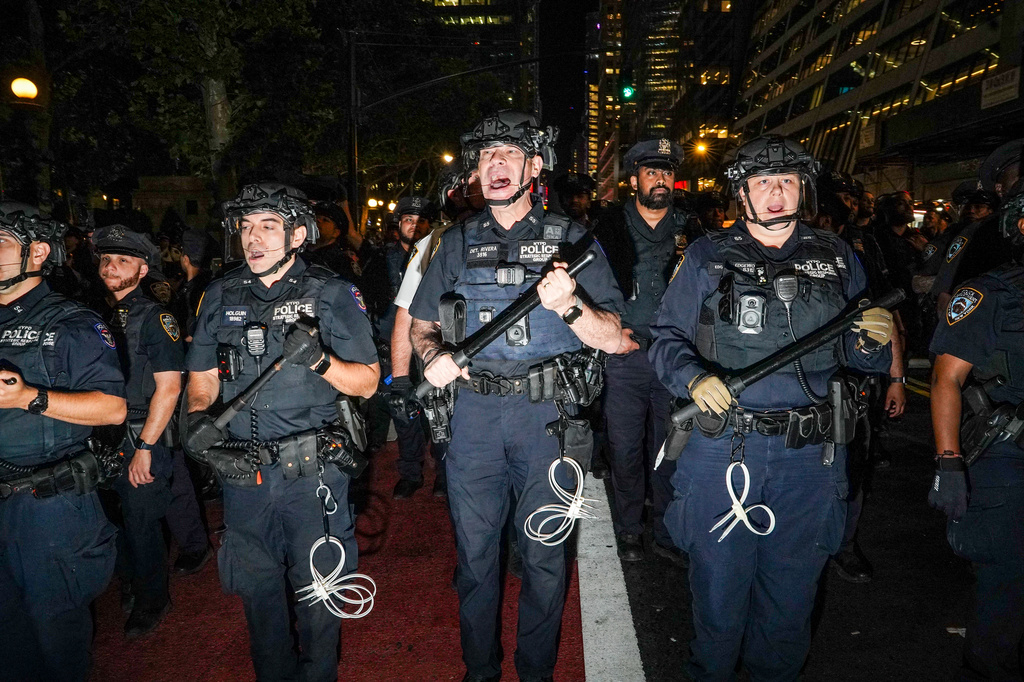 NYPD officers push New York Knicks fans back outside of a watch party in Bryant Park for Game 3 of the NBA Finals basketball series between the Knicks and the San Antonio Spurs, Monday, June 8, 2026, in New York. (AP Photo/Ryan Murphy)