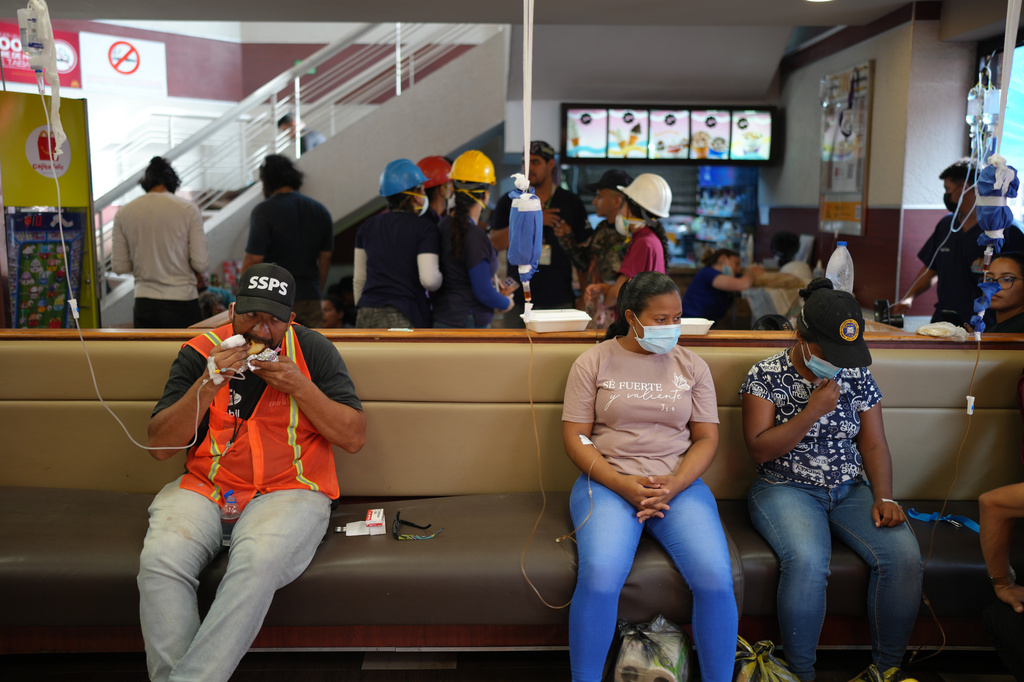 A man connected to an IV eats a hamburger at a McDonald's restaurant being used as a temporary health center and pet reunification center after the earthquakes that struck La Guaira, Venezuela, Thursday, July 2, 2026. (AP Photo/Matias Delacroix)