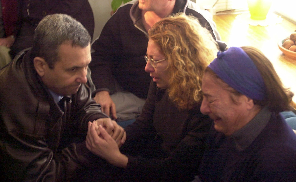 FILE.- Israeli Prime Minister Ehud Barak kneels as he comforts Shoshi Malchi mother of Tzahi and his grandmother at their home in Metula, Feb. 1, 2000. Tzhai is one of three Israeli soldiers that were killed in a Hezbollah attack on an Israeli outpost in south Lebanon. (AP Photo/Eyal Warshavsky,File)